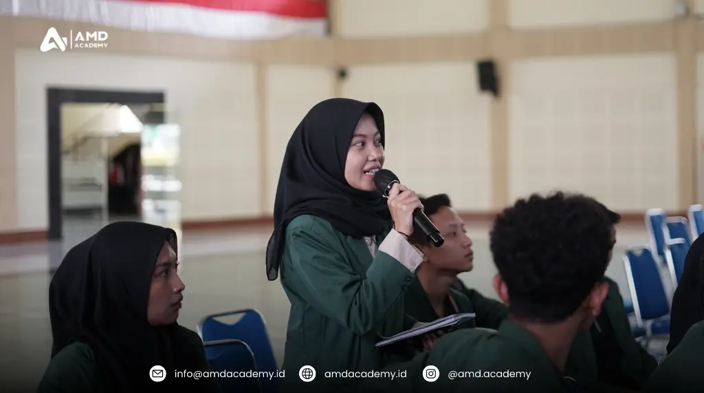 Mahasiswi Polbangtan Malang berdiri sambil memegang mikrofon dan bertanya kepada pemateri di tengah sesi pelatihan dan sertifikasi BNSP digital marketing bersama AMD Academy di aula kampus.